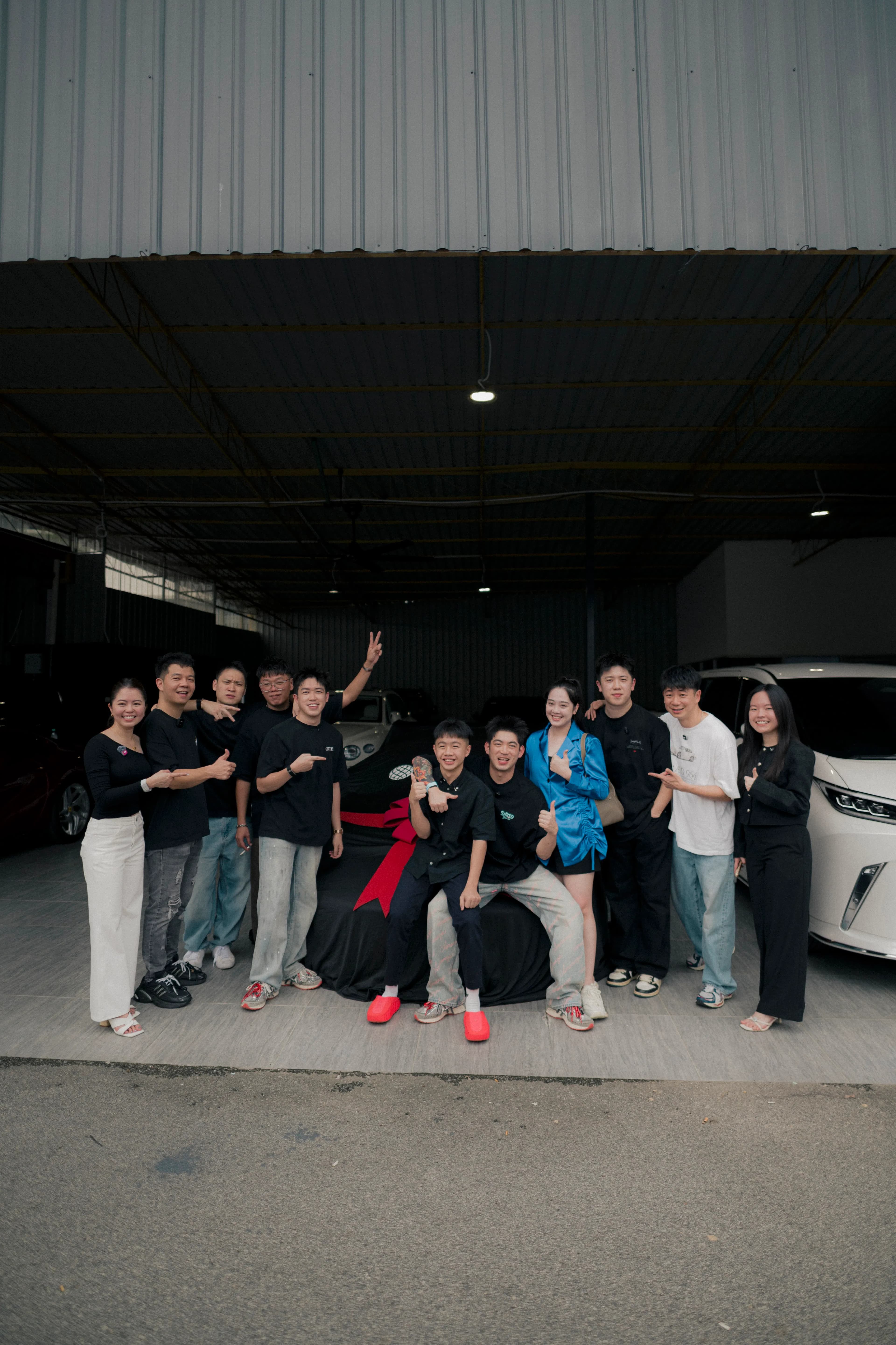 D&Dream team celebrating the car reveal in the warehouse