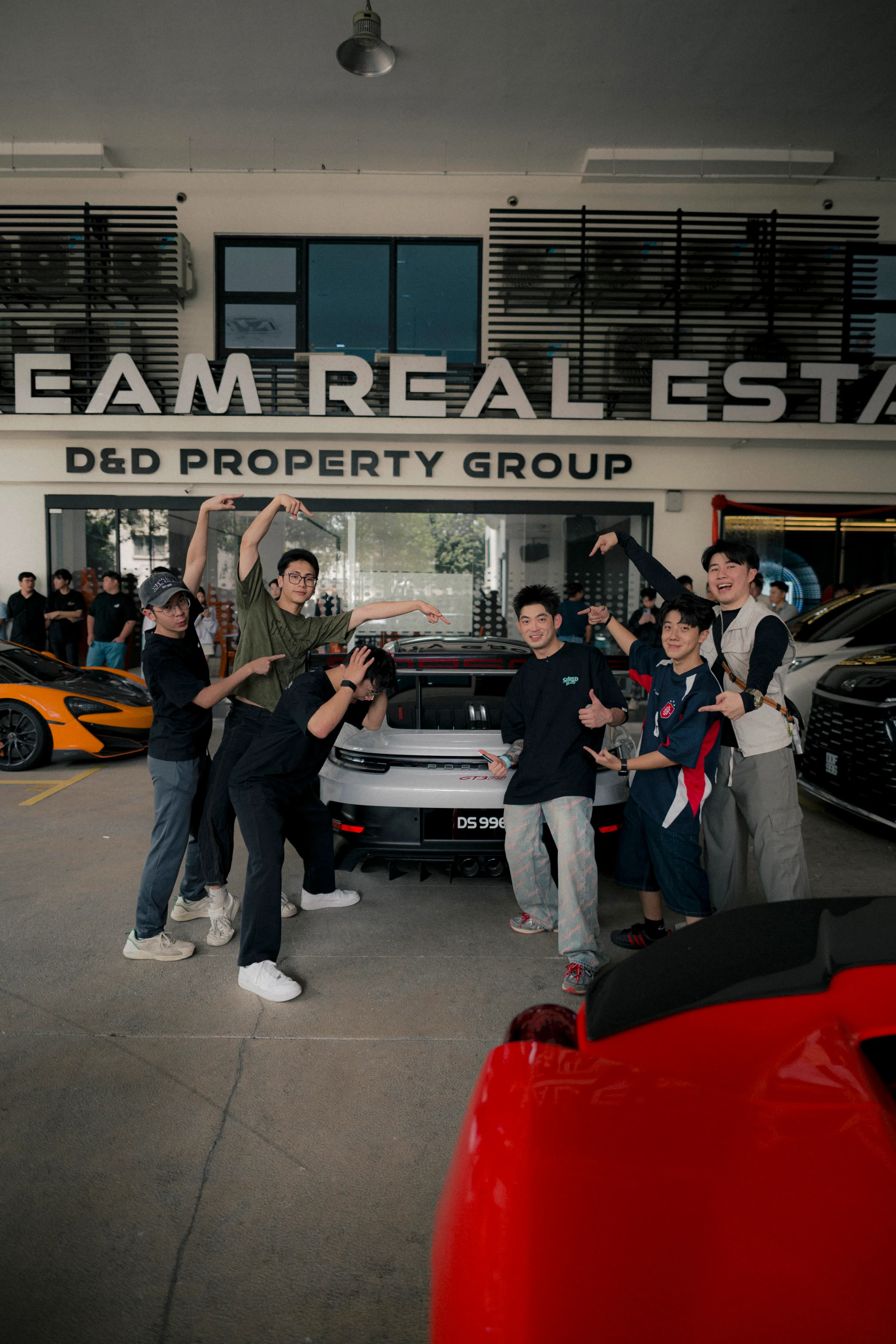 Team posing around the Porsche GT3 RS at Dream Real Estate