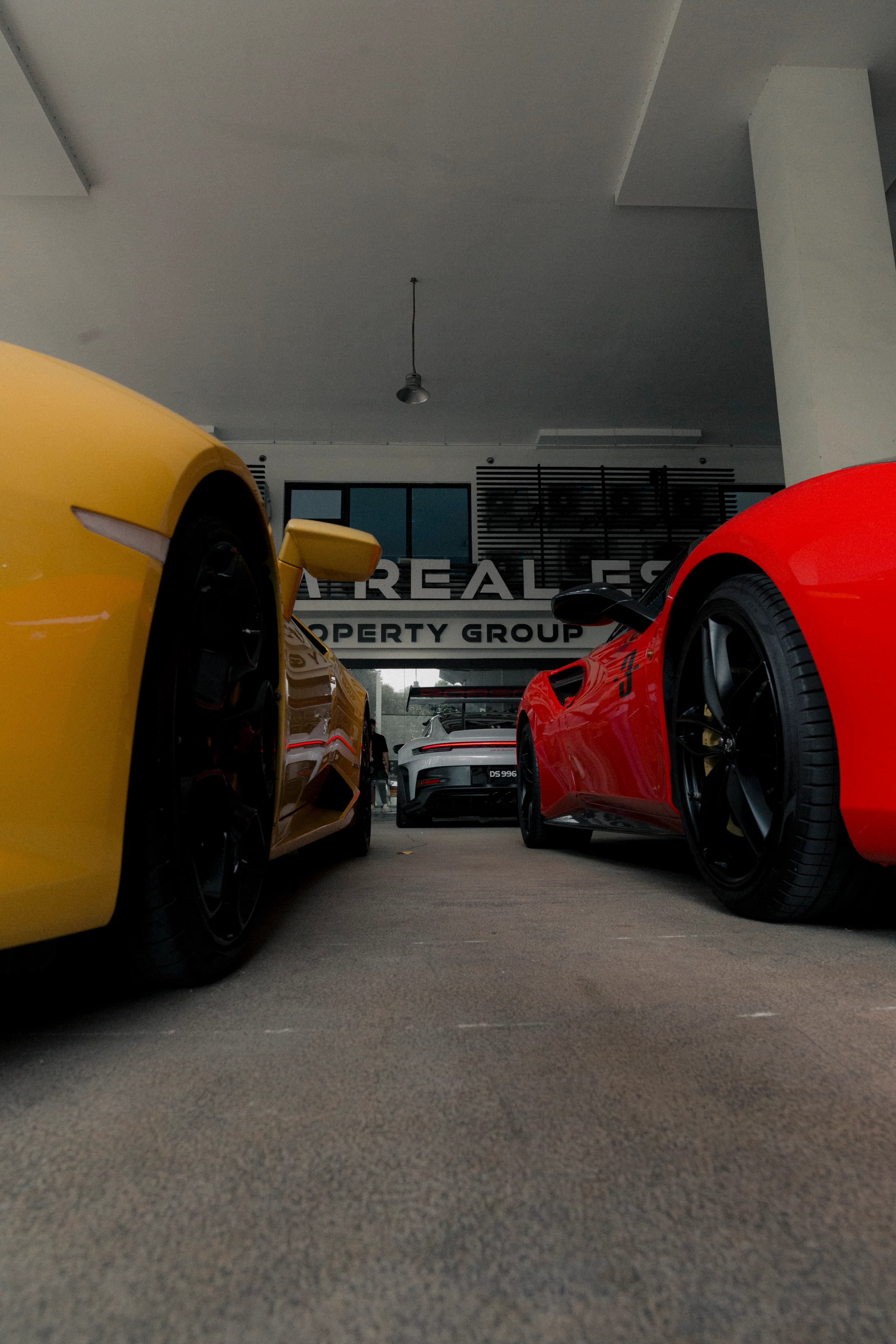Yellow and red supercars framing a white Porsche GT3 RS at the D&Dream showroom